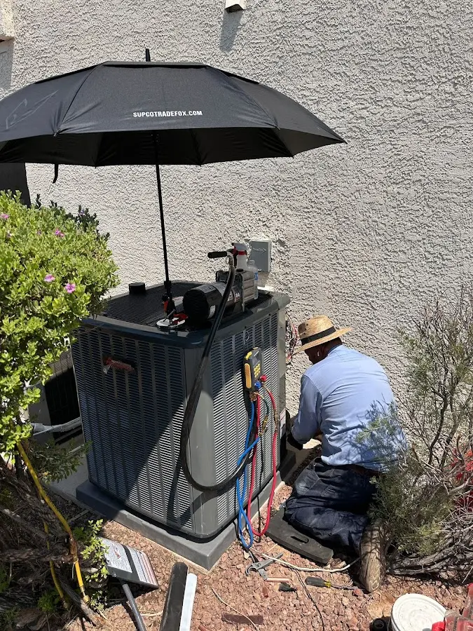 HVAC technician performing outdoor AC maintenance in Wickenburg